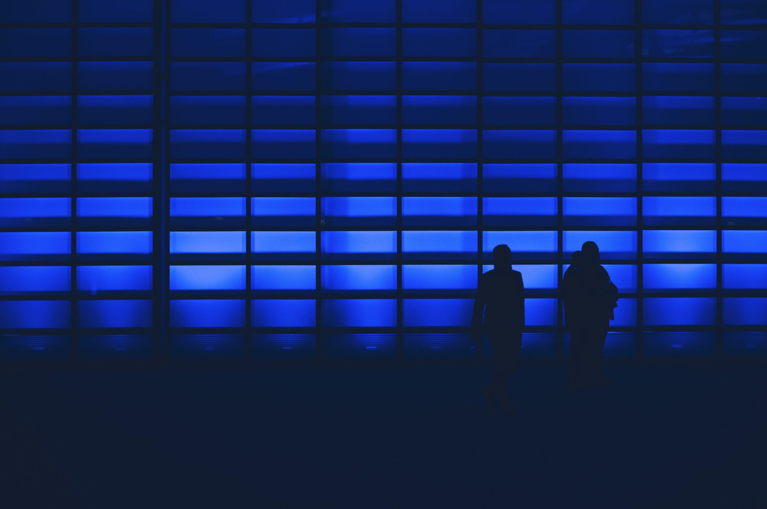 photo de silhouette de deux personnes debout près du mur